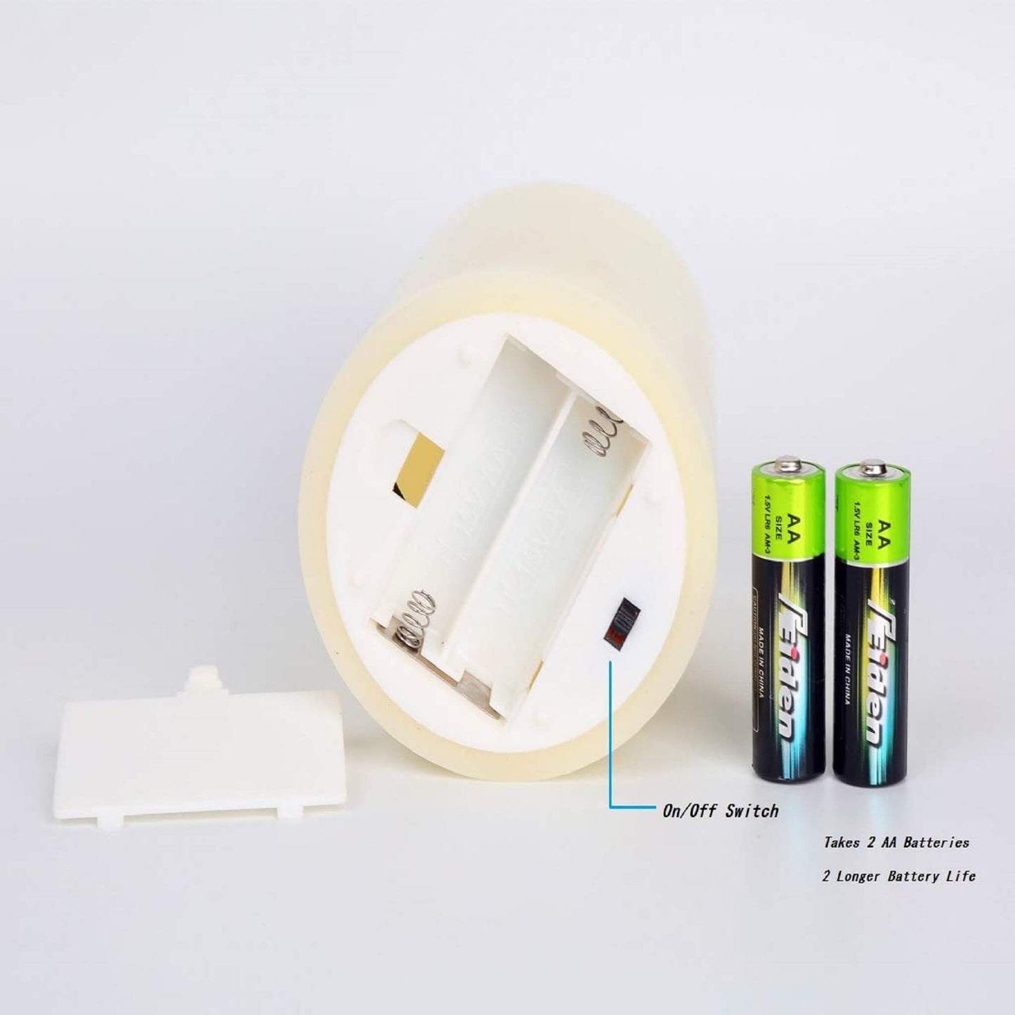 The bottom of one LED ivory timer flameless candles is turned on, showing that 2 AA batteries are needed