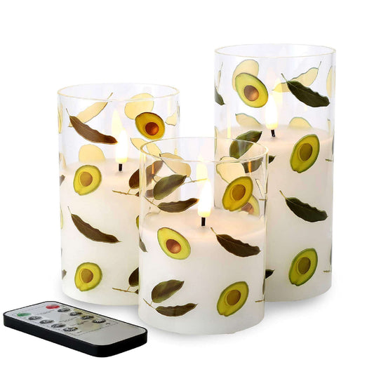 three avocado-shaped glass flameless candles sitting on a white surface, all three candles were lit, giving off a yellow glow. there is also a remote control next to it