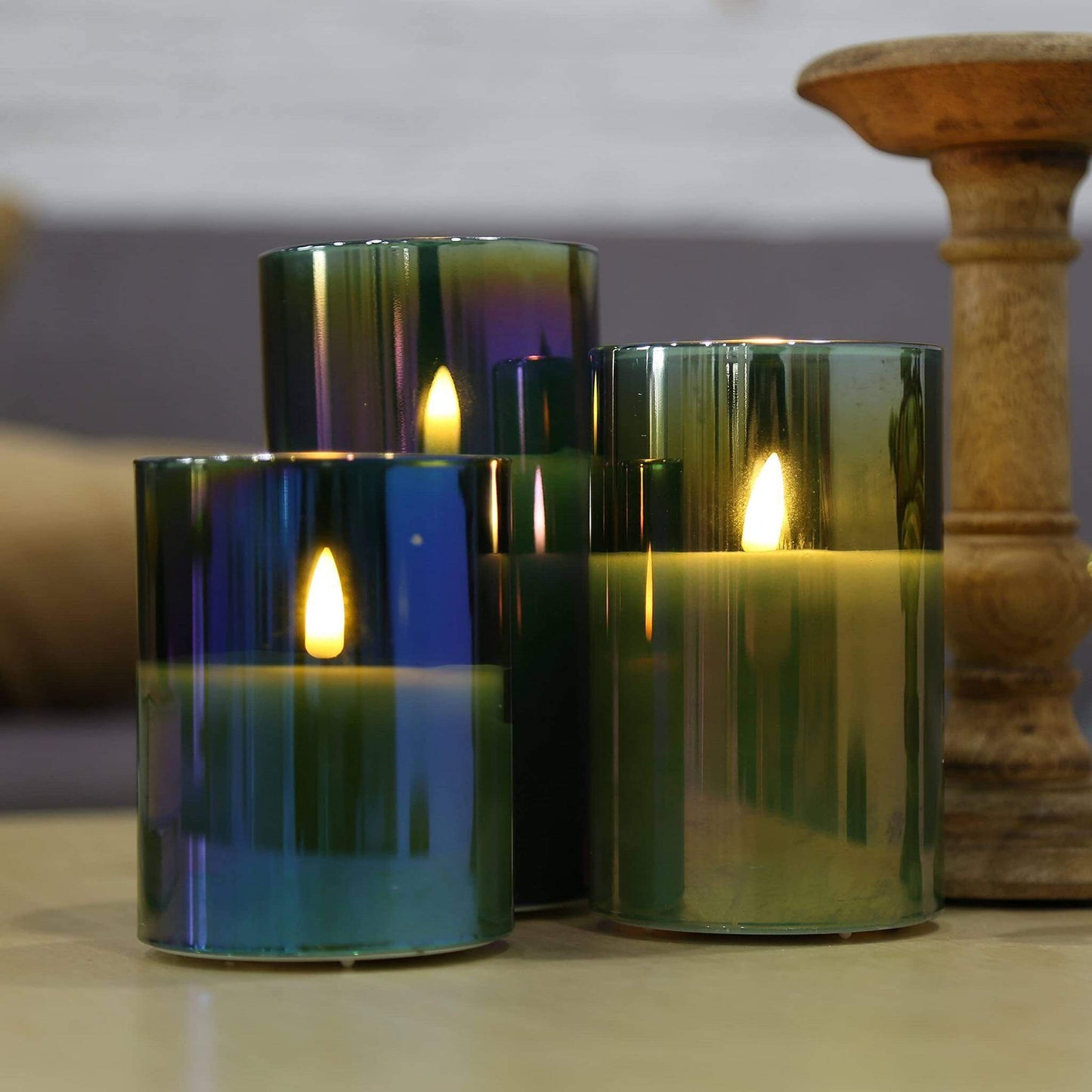 3 eywamage green glass flameless candles on the table in front of the sofa with a candle holder next to it