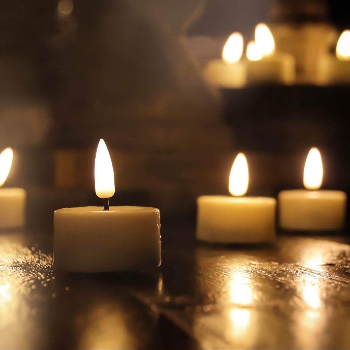 some eywamage flameless tealight candles, lit and placed on a table in a dark environment