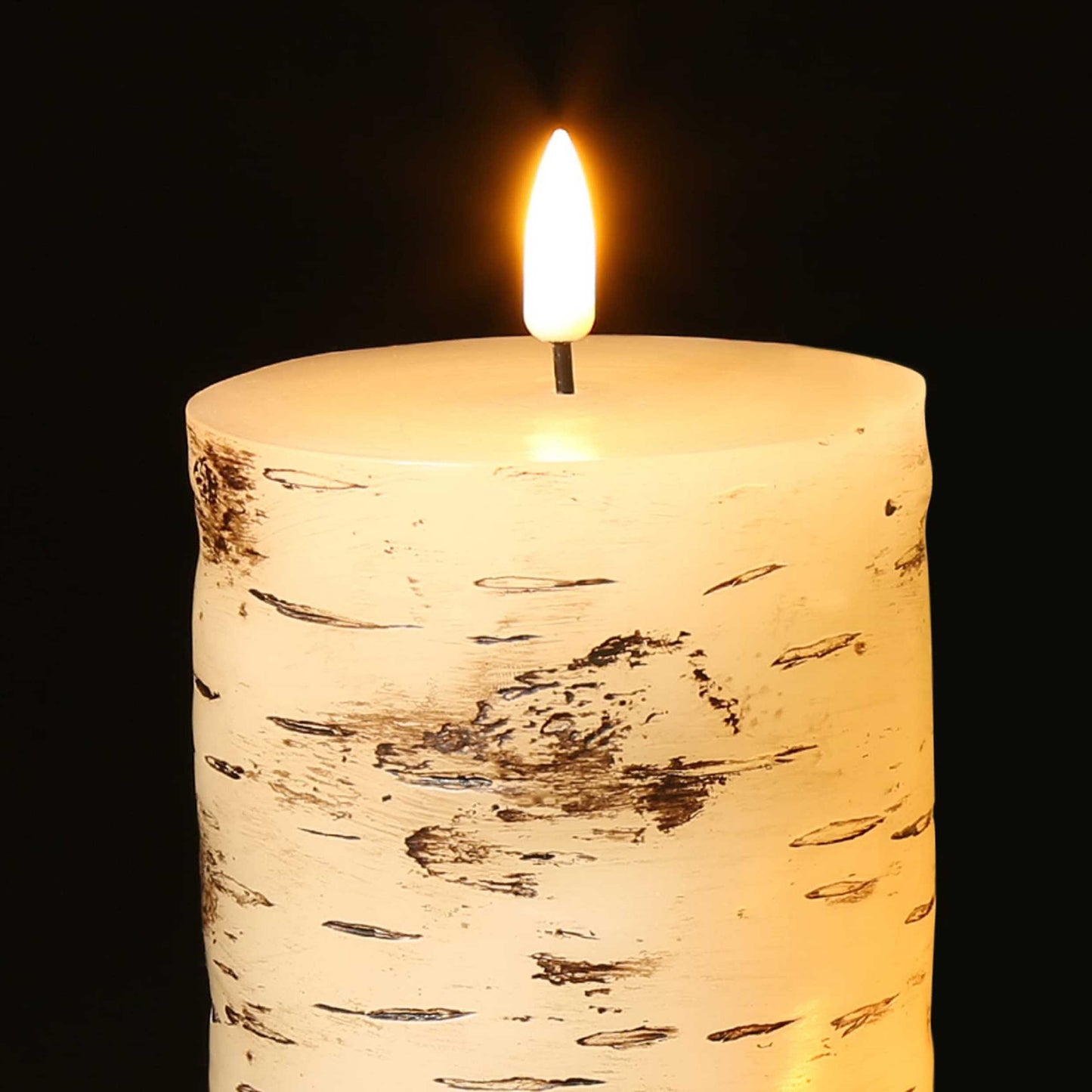 The top half of an electric eywamage birch pattern pillar candle