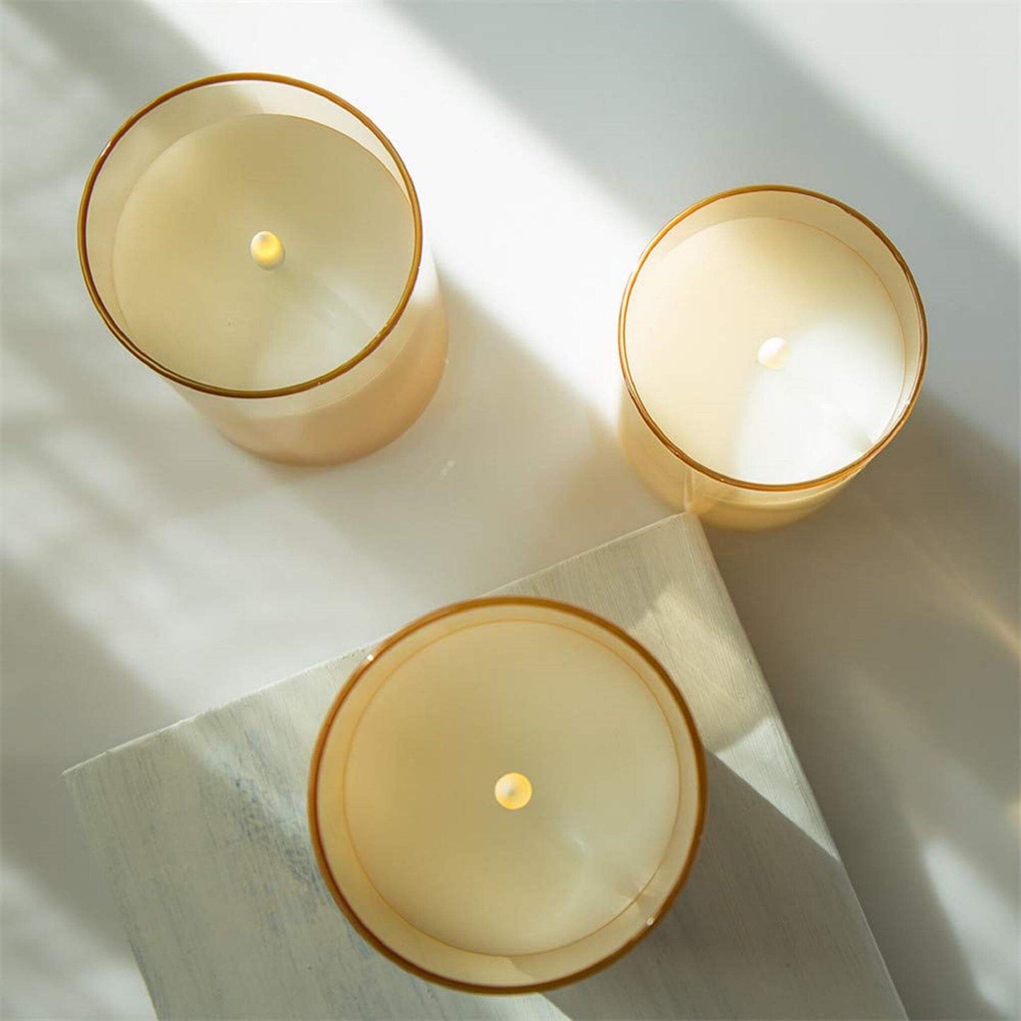 Three eywamage gold glass flameless candles placed on the table from top view