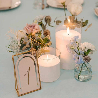 On the dining table are two transparent glass flameless candles and three sets of cutlery. There are also aromatherapy, bouquets, ornaments as decorations